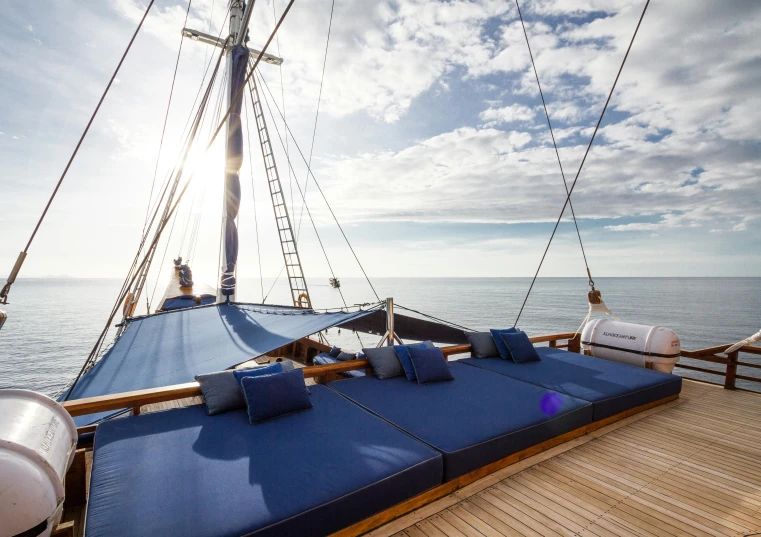 an open deck with blue cushions in the sunlight