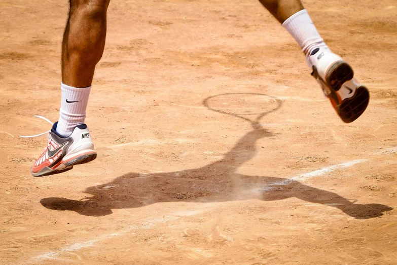 someone wearing white socks and red shoes playing tennis