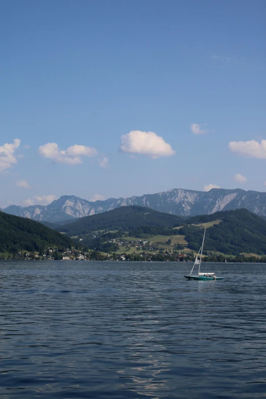 a boat sailing on a large body of water with mountains in the distance