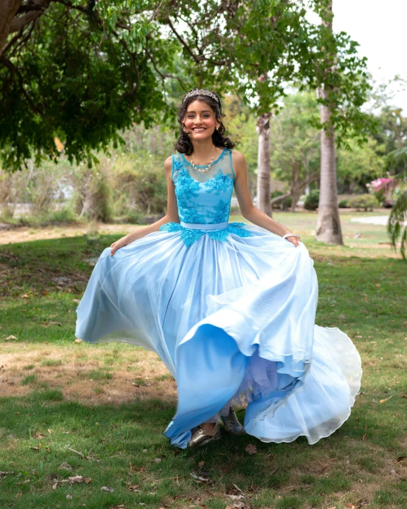 a girl is sitting on the ground in her dress
