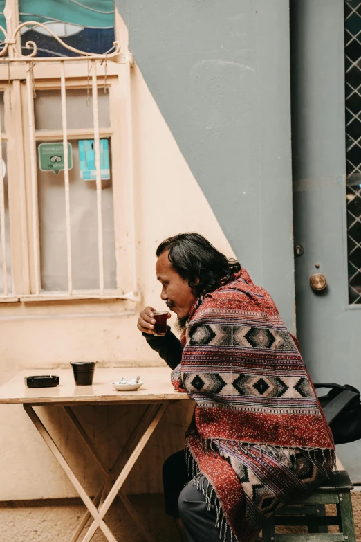 a person sitting at a table eating soing