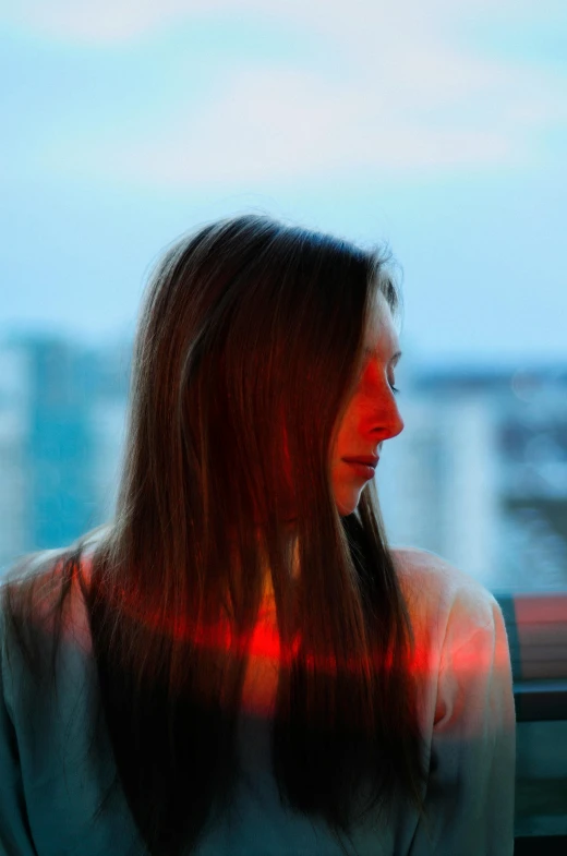 a woman staring into the distance with red light