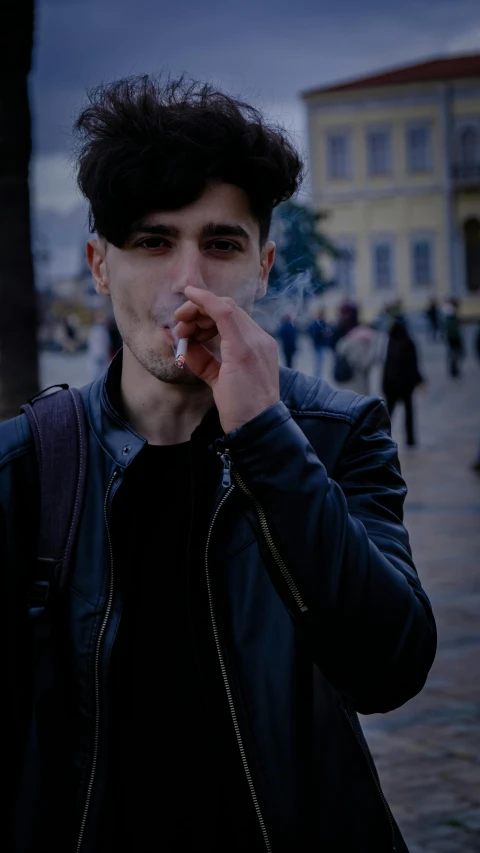man with cigarette in mouth on a city sidewalk