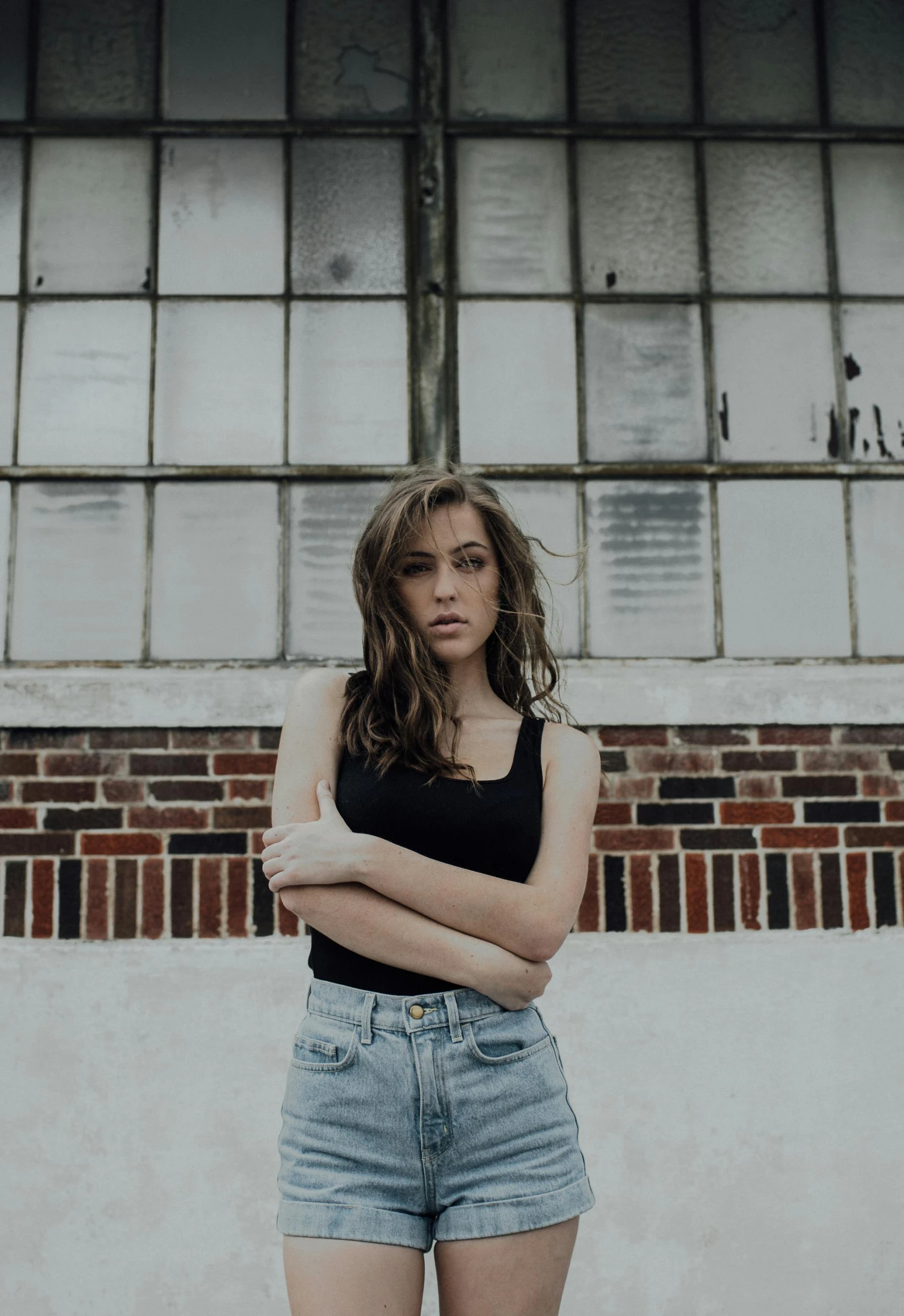 a woman stands with her arms crossed