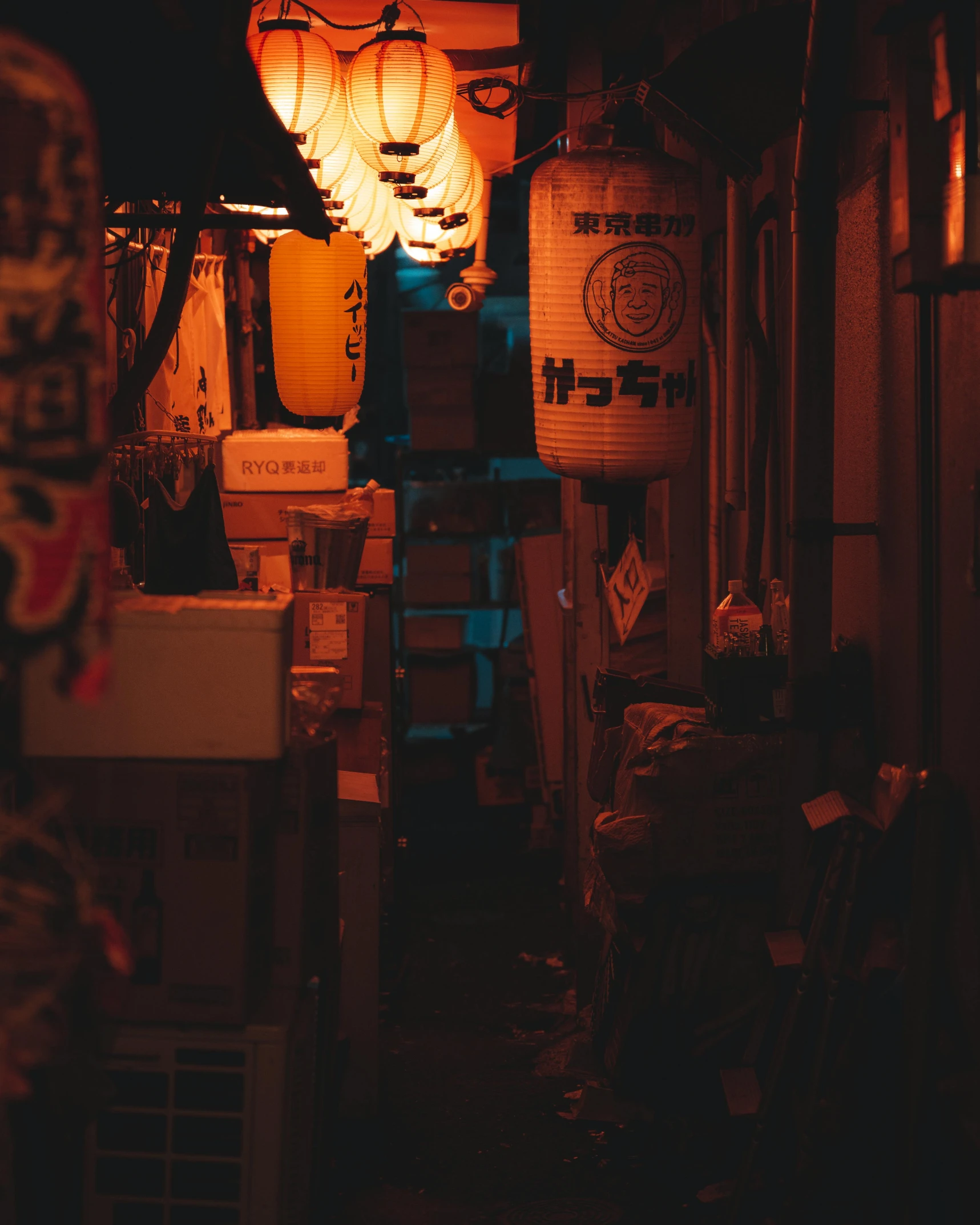 a narrow alley way covered with lights in the dark