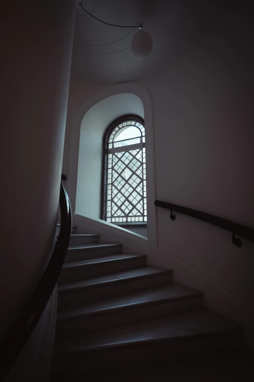 a staircase with some light coming in through a window