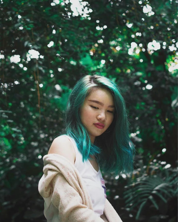 young asian woman with green hair in the forest