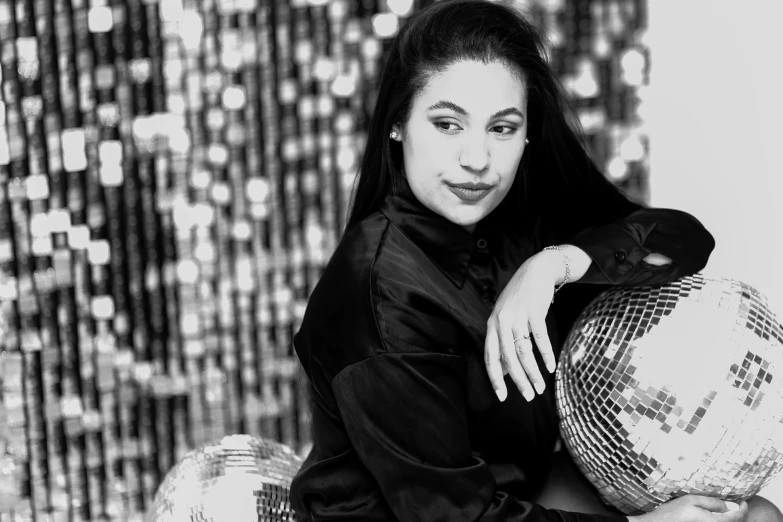 black and white image of a woman holding a disco ball