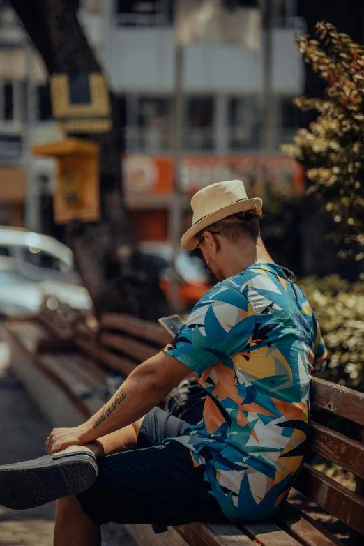 a man is sitting on a bench with his foot up