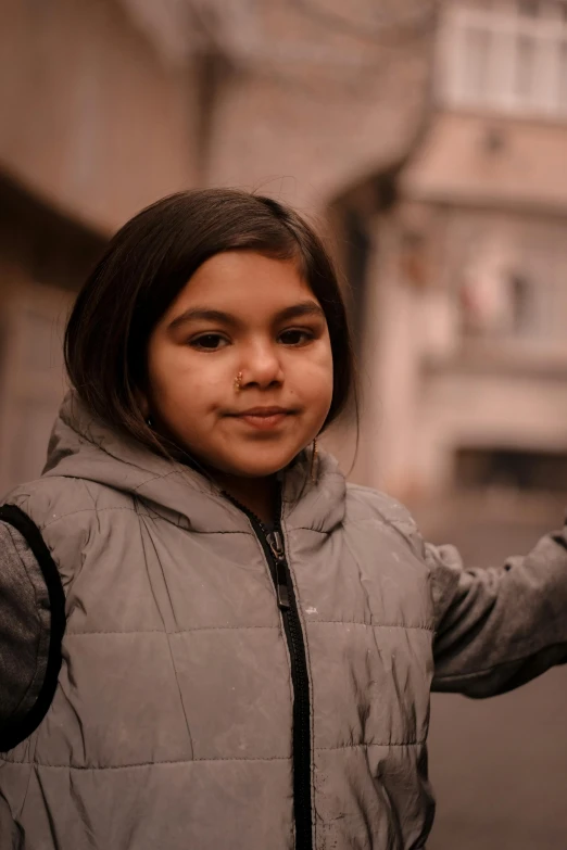 a girl in a light gray vest is on the street