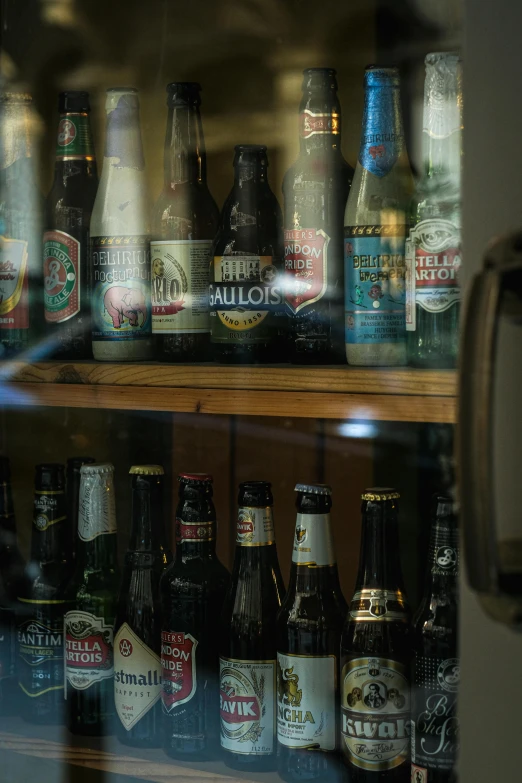 several bottles of alcohol sitting on a wooden shelf