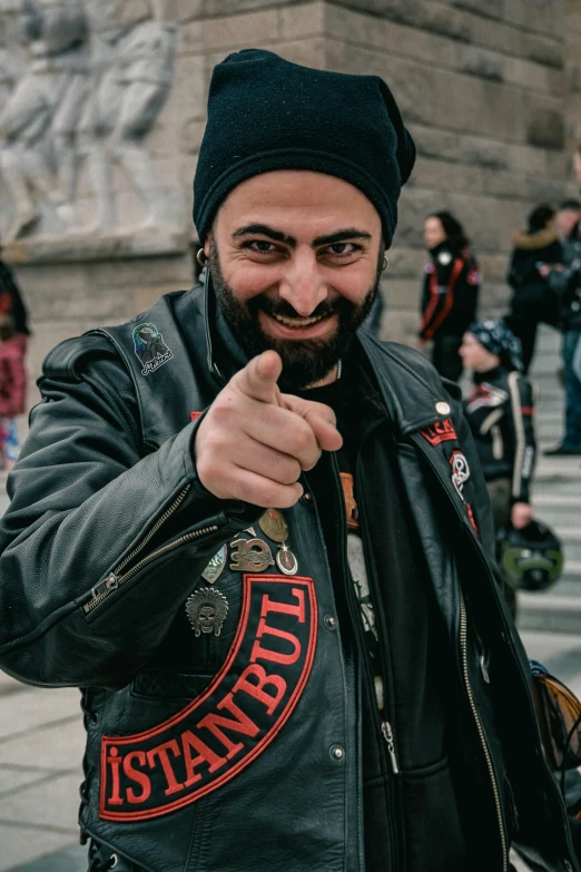 a bearded man pointing a finger at the camera