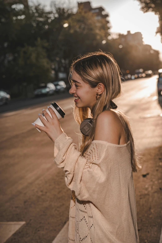 a girl standing on a sidewalk holding onto a container