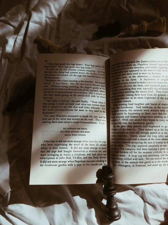 an open book on a bed with sheets