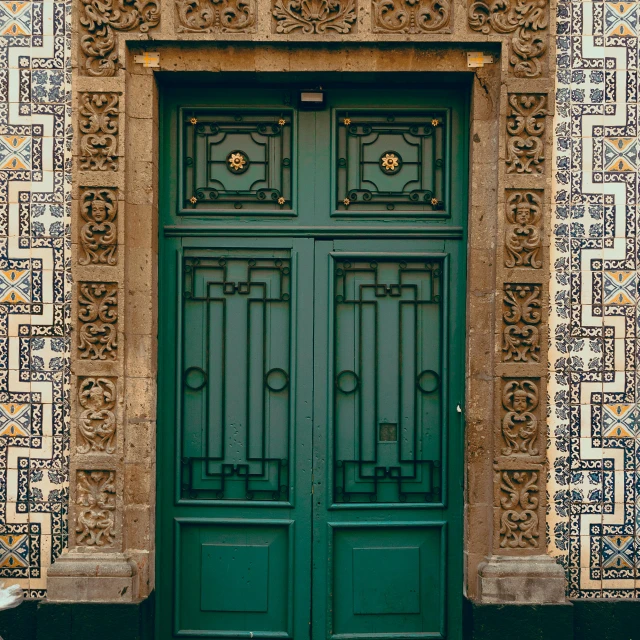 two green doors that are against a building