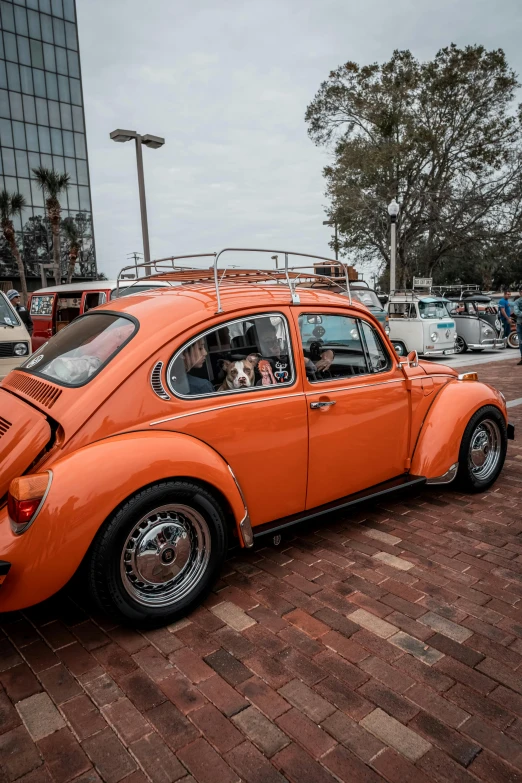 an orange beetle sitting in a parking lot
