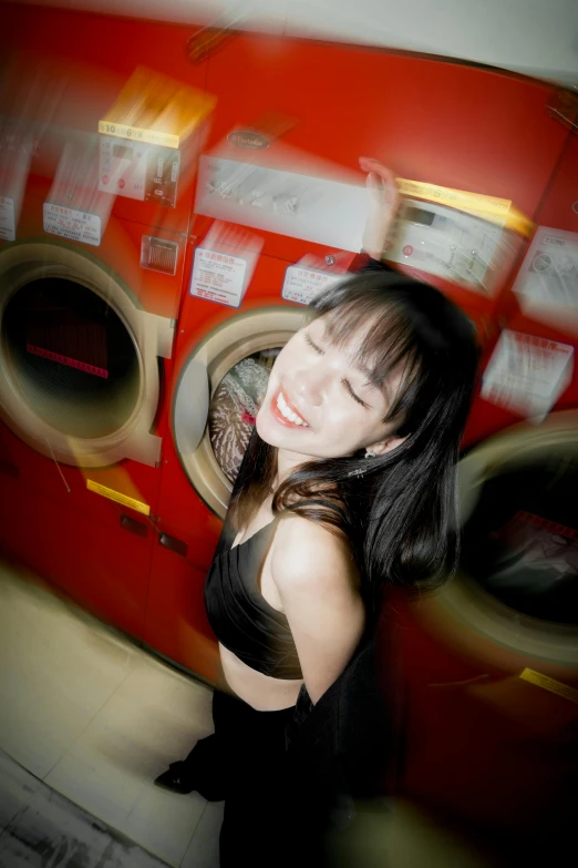 a woman is posing in front of a washer