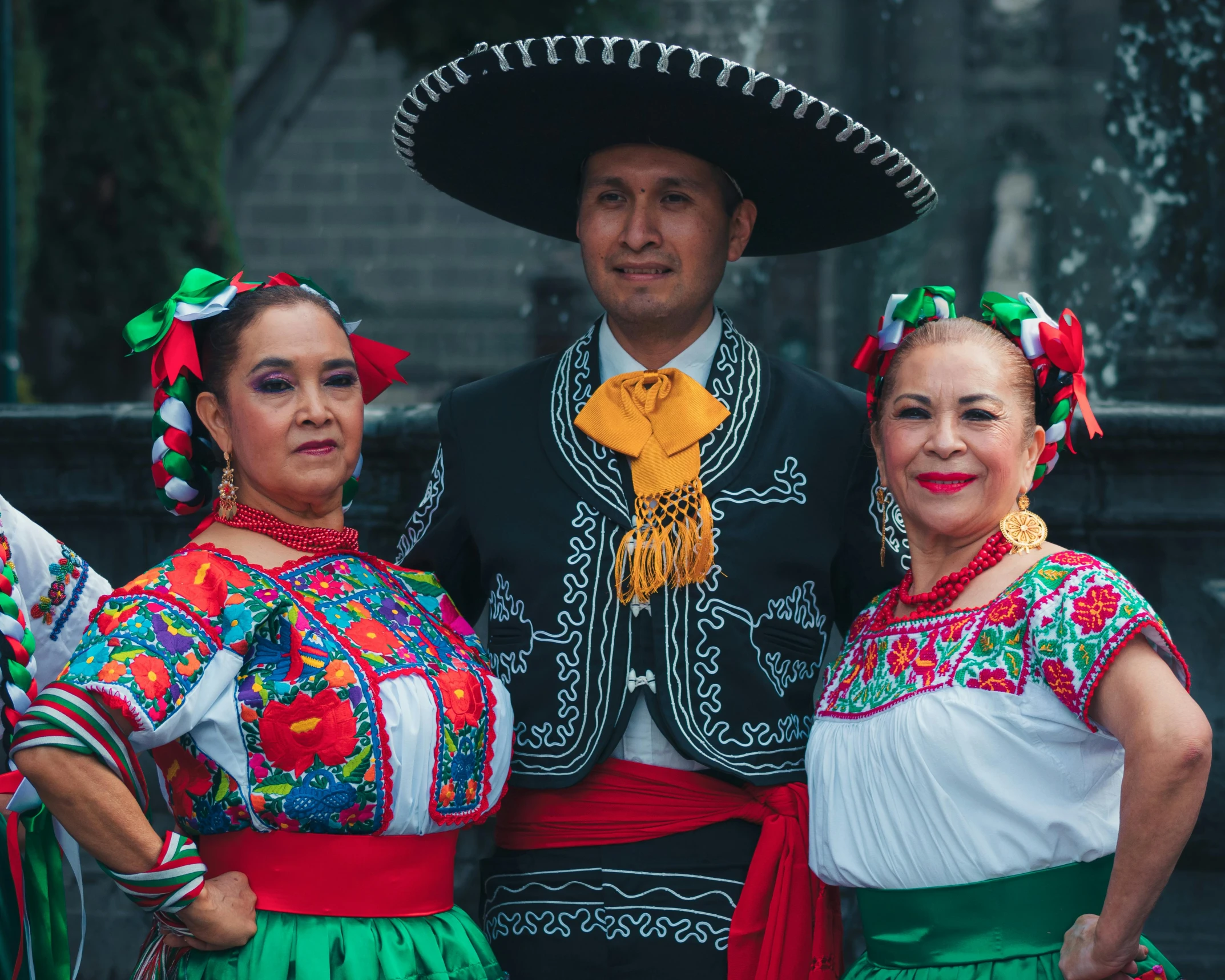 three people in colorful outfits standing next to each other