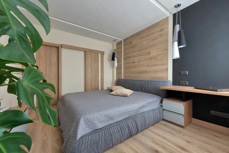 a bed sits in the middle of a room near a wooden table