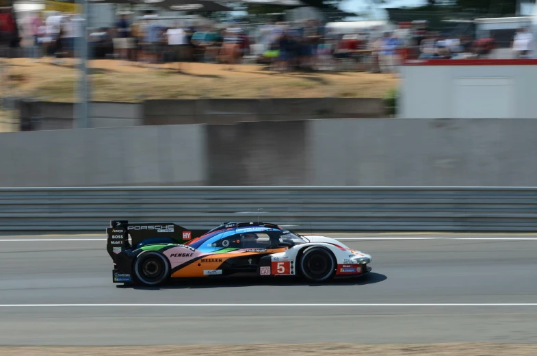 a car is racing down a track with spectators watching