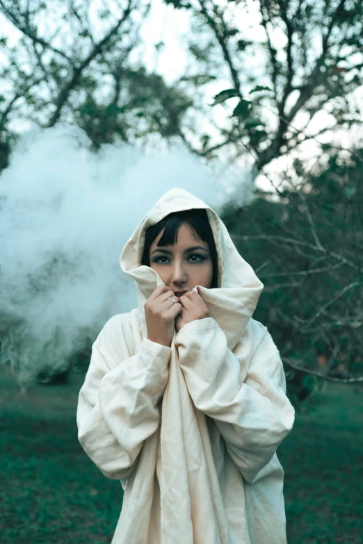 a person is wearing a robe and smoke in the background