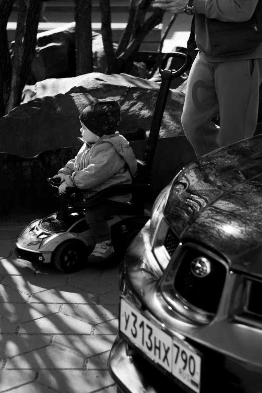 a child on a motorized scooter by some parked cars