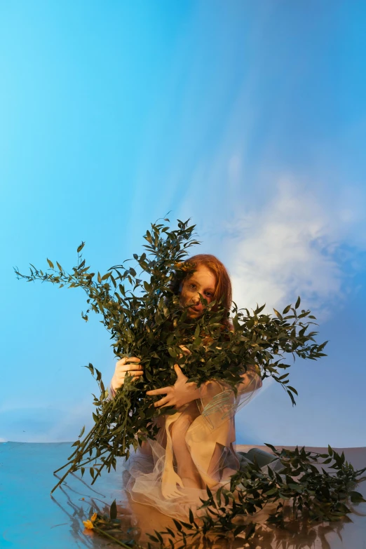 a woman holds a bunch of leaves against the camera