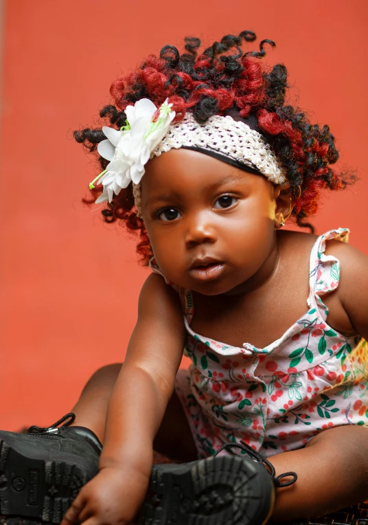 little african american girl sitting on a floor with hair pulled back