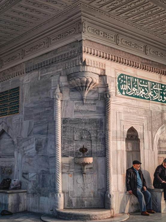 a man sits in a doorway next to a building