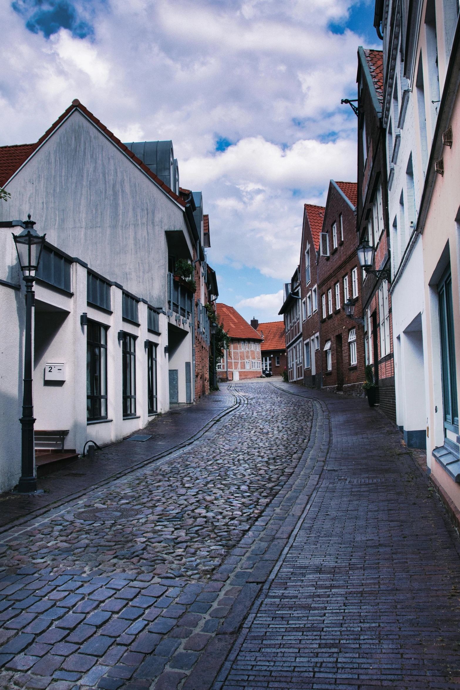 an old cobblestone street with a building near by