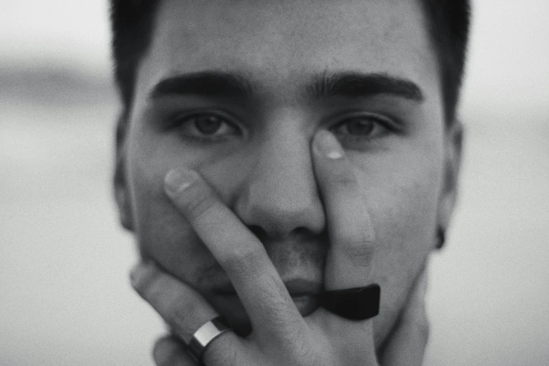 man with his hand on his face and finger under nose