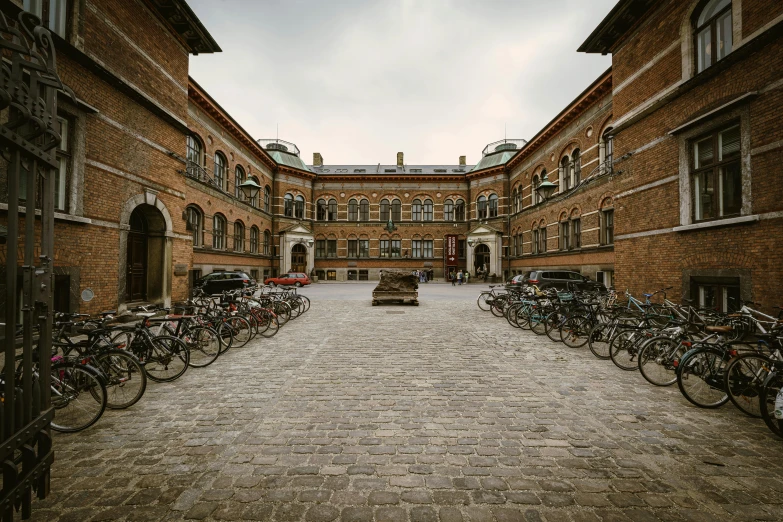 a stone walkway leading to two large buildings with bicycles parked