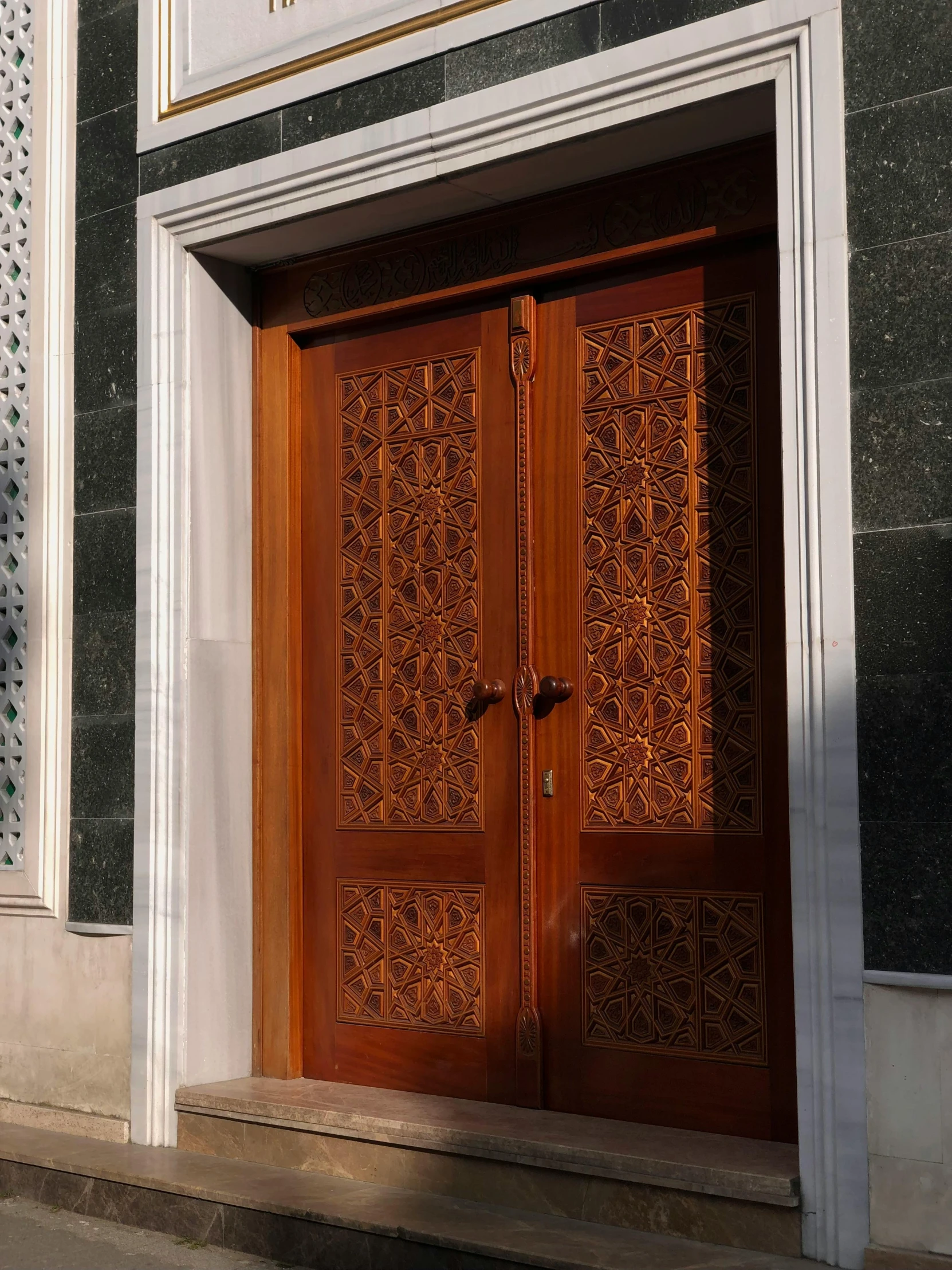 two wooden doors sitting outside of a tall white building