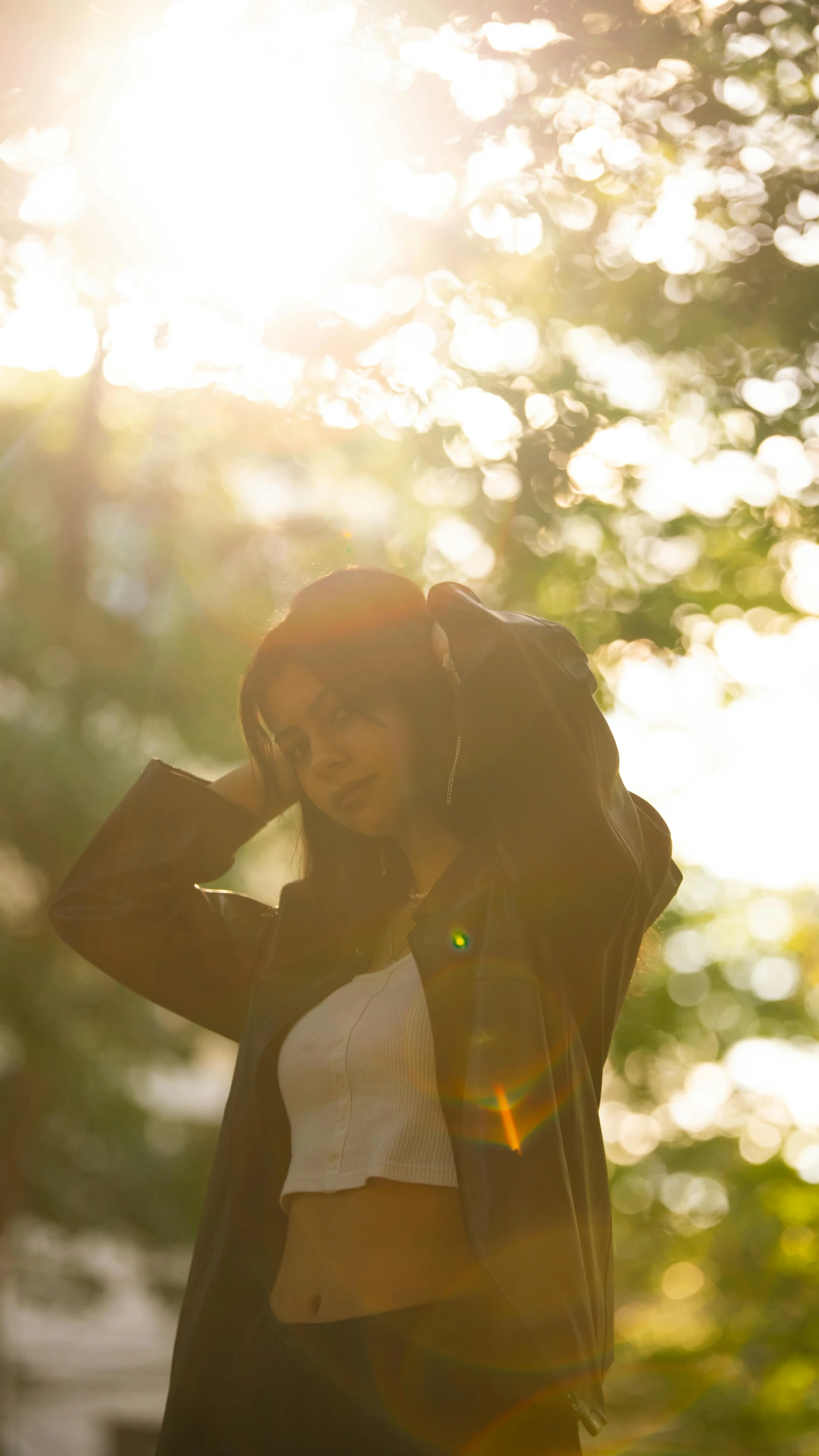 a woman with headphones on and her jacket blowing in the wind