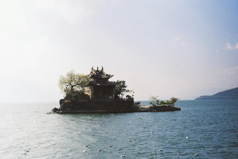 a floating house is made of rocks in a large body of water