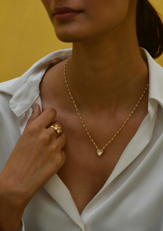 a lady is wearing a gold chain and a necklace