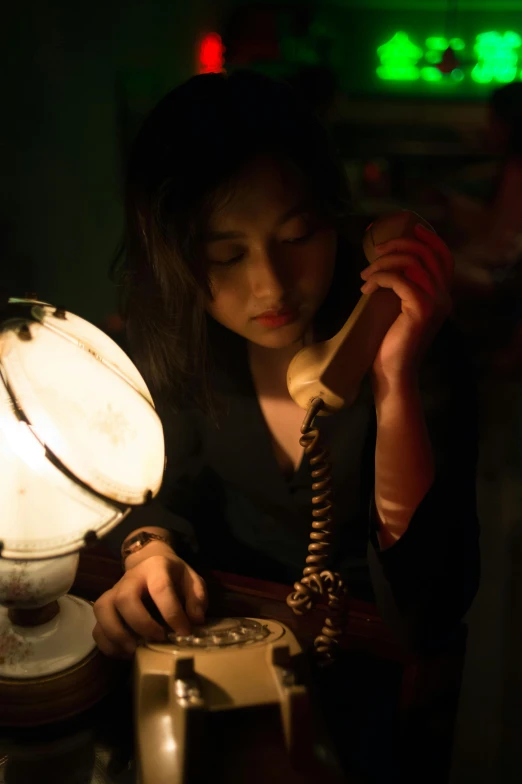 a woman on a phone sits in the dark