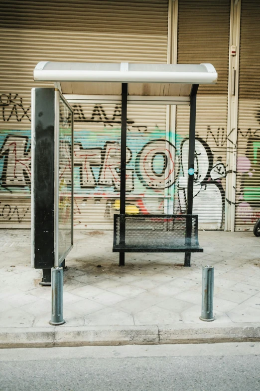 a bench next to graffiti in front of a storage door