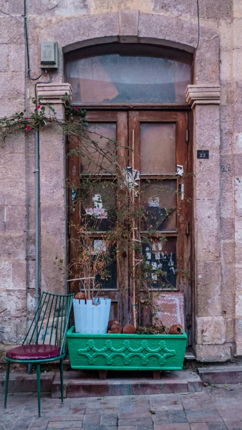 a bench and chair are sitting outside on the side of a building