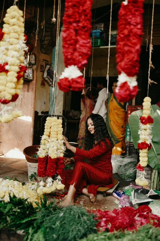 a person is sitting down next to a bunch of flowers