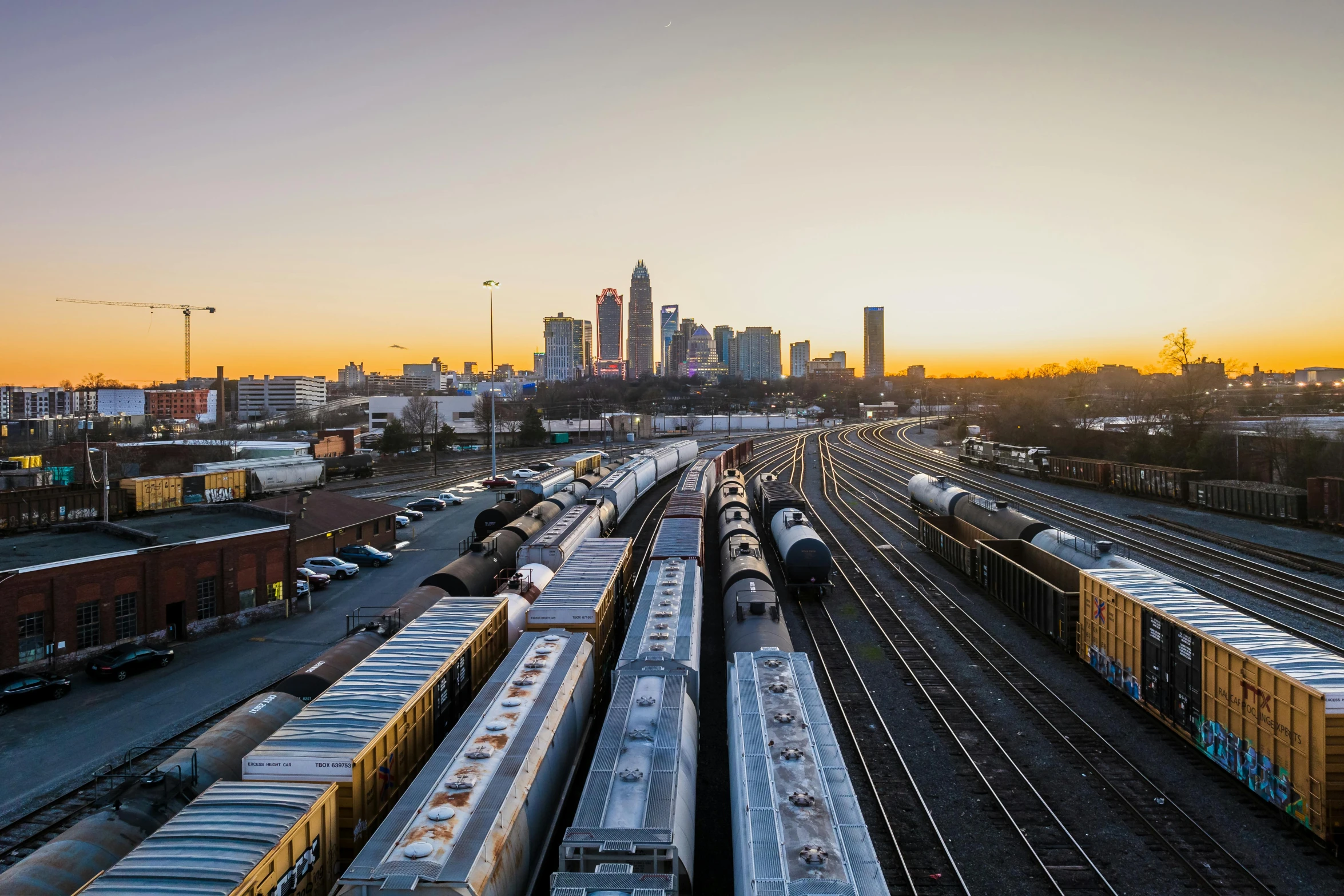 a city skyline and train yard with trains parked at their depots