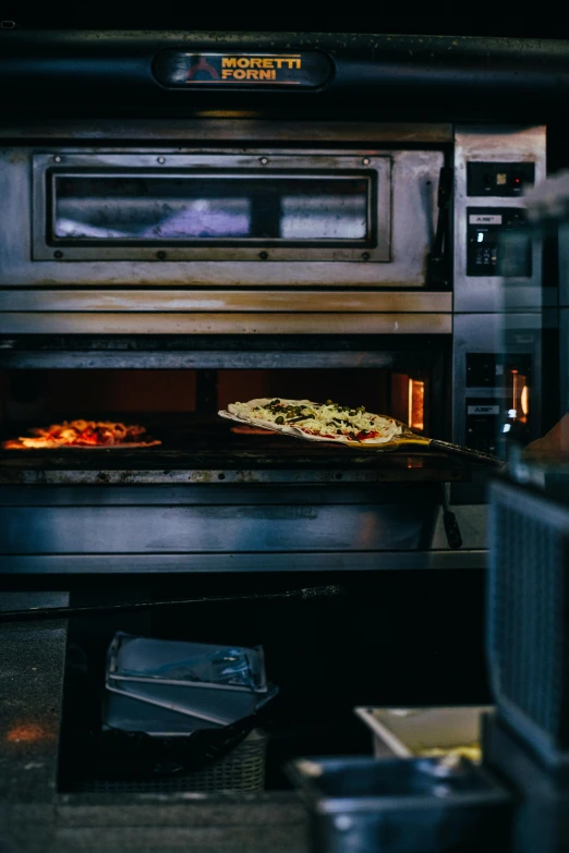 a metal stove with food cooking inside of it