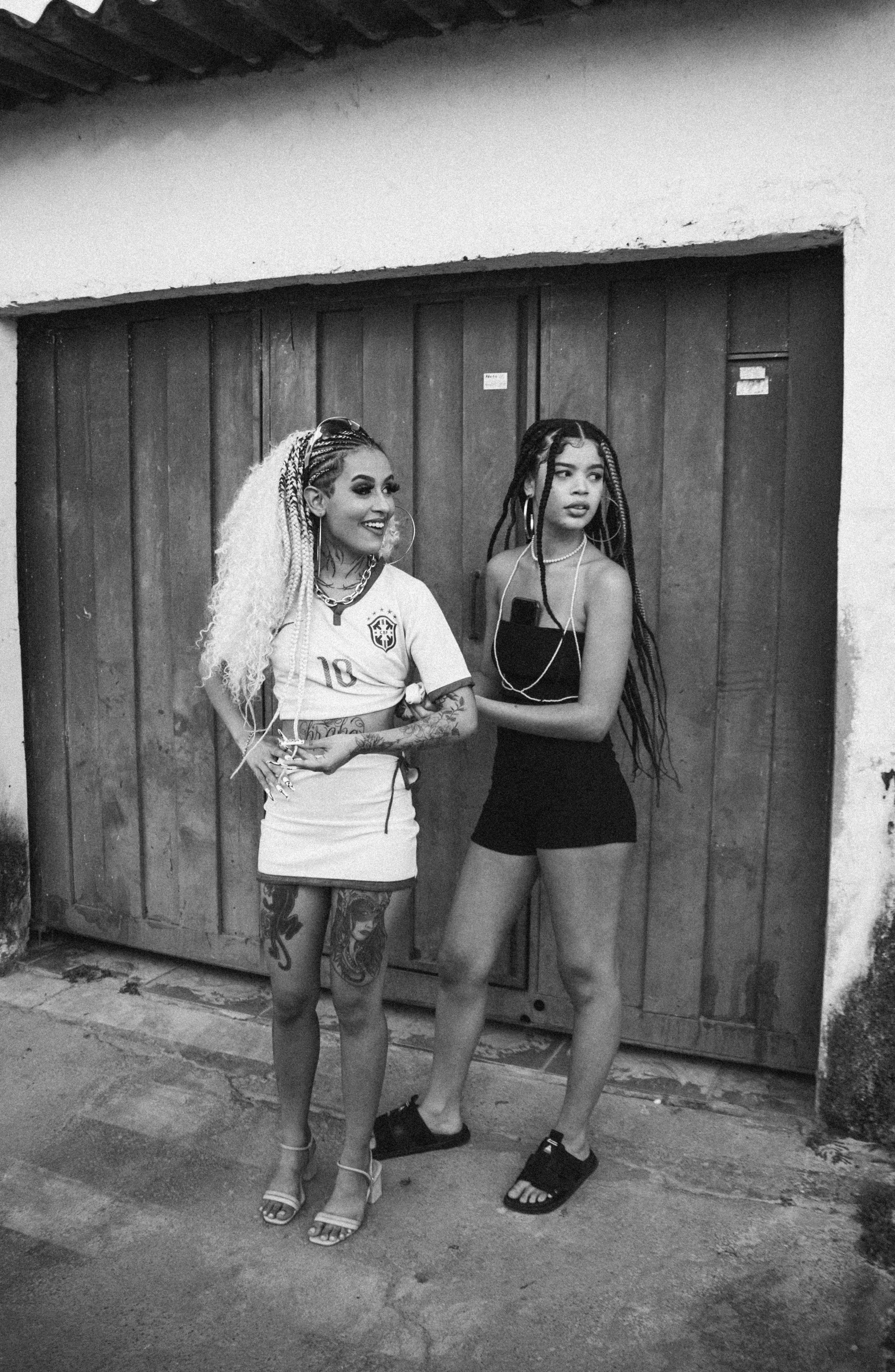 a couple of women that are standing in front of a garage