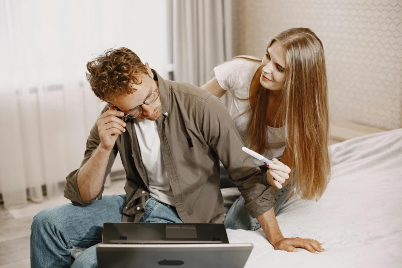 a man and woman look at their cell phones