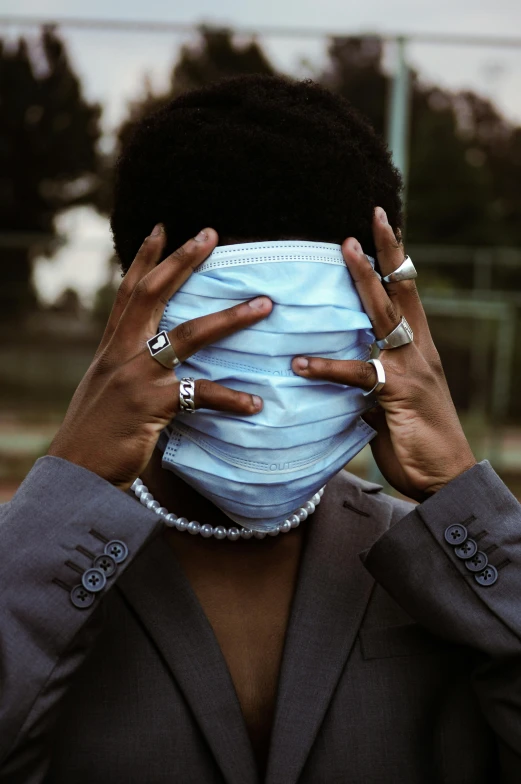 the woman with the blue protective mask has black hands on her face