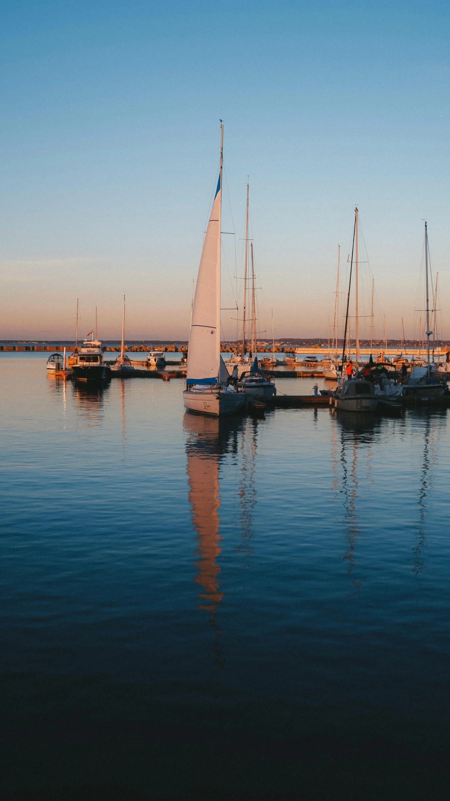 some sail boats are in the water and the sky