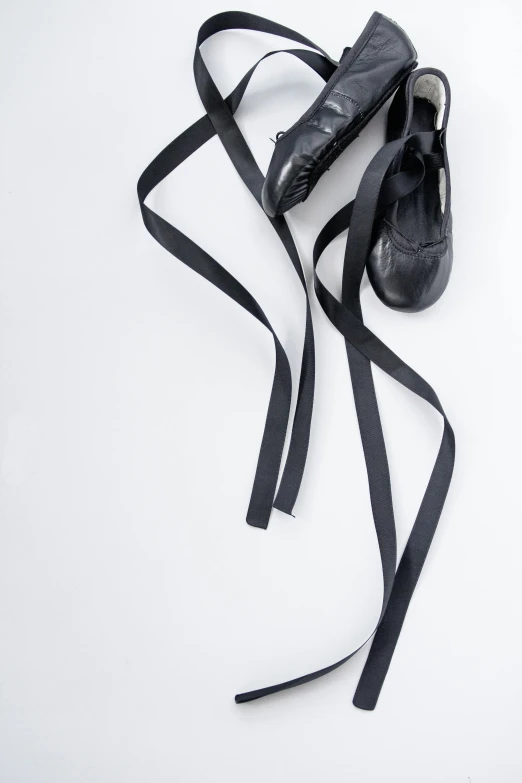 two pairs of black shoes, tied together