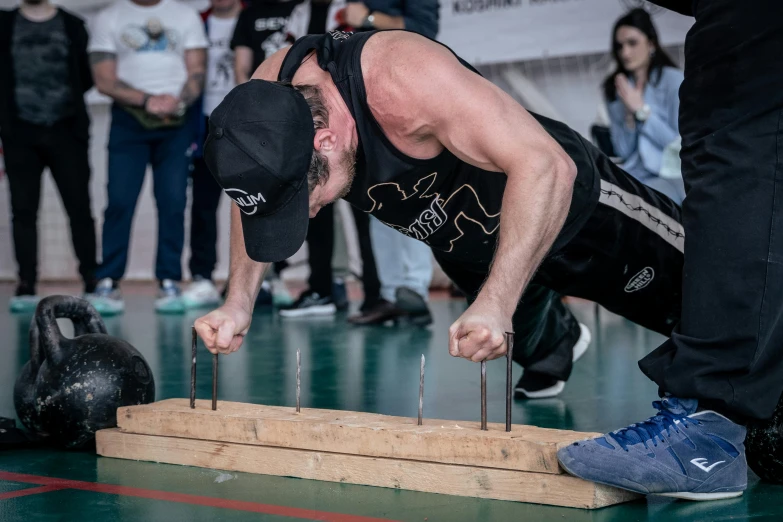 a person standing with their hands in the air while holding a skateboard with two nails on it