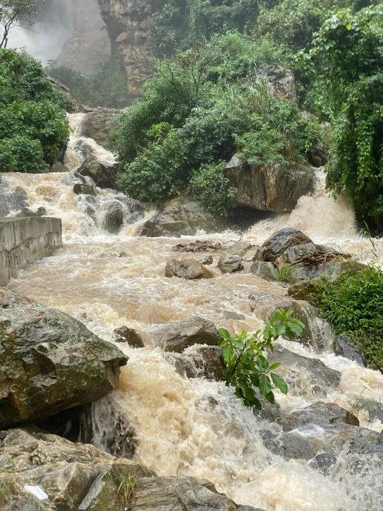 the rocks are in the water next to a waterfall