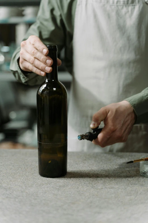 the chef is holding an empty bottle of beer